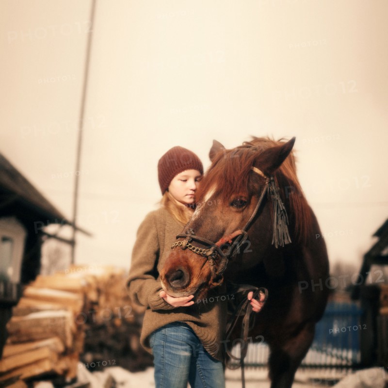 Caucasian girl holding rein of horse
