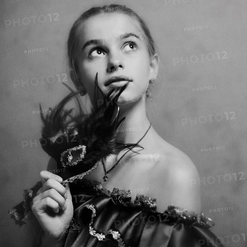 Caucasian girl holding feather mask