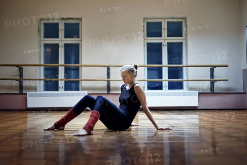 Caucasian dancer sitting on studio floor