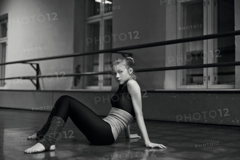 Caucasian dancer sitting on studio floor