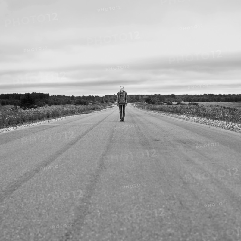 Caucasian girl standing on empty rural road