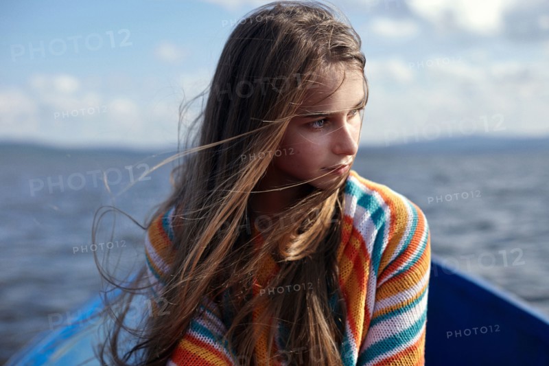 Caucasian teenage girl in canoe on lake