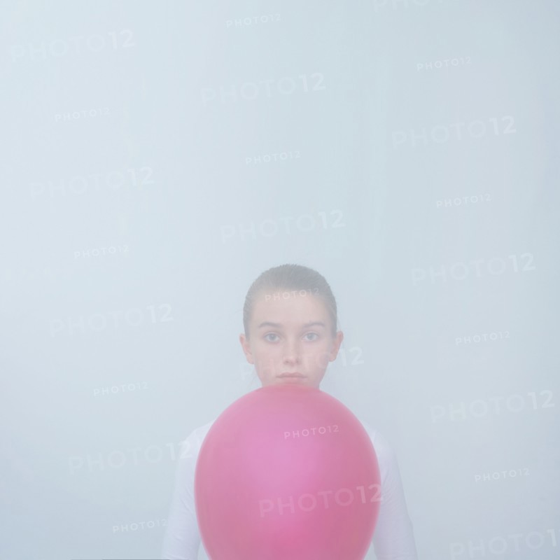 Caucasian teenage girl holding balloon