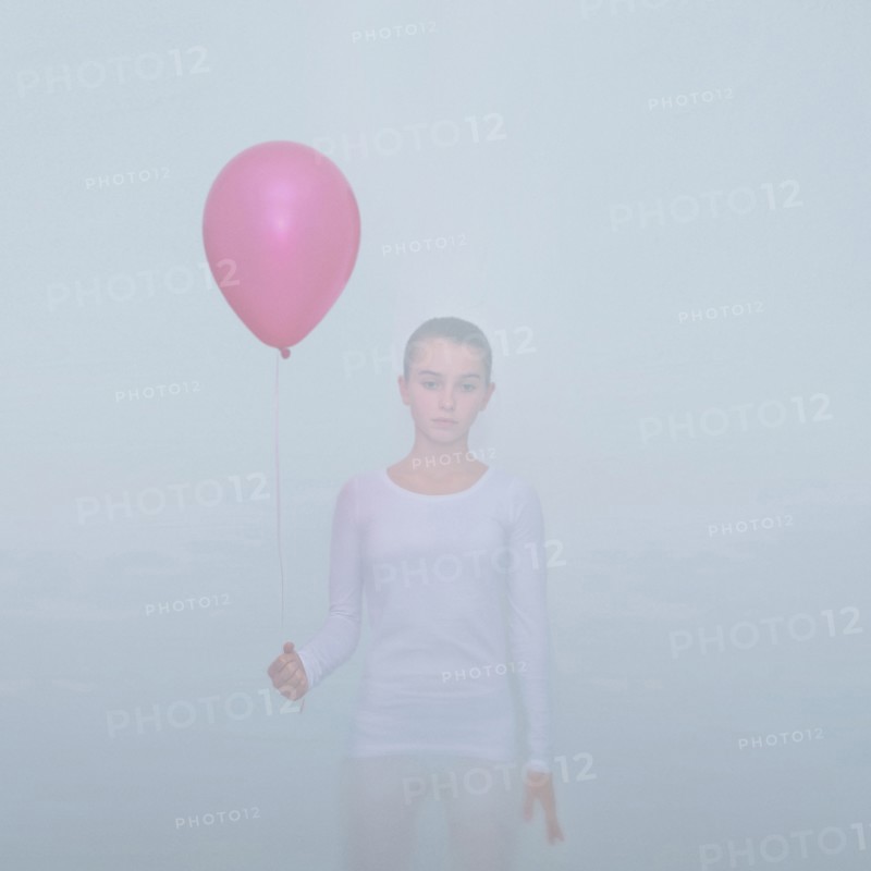Caucasian teenage girl holding balloon