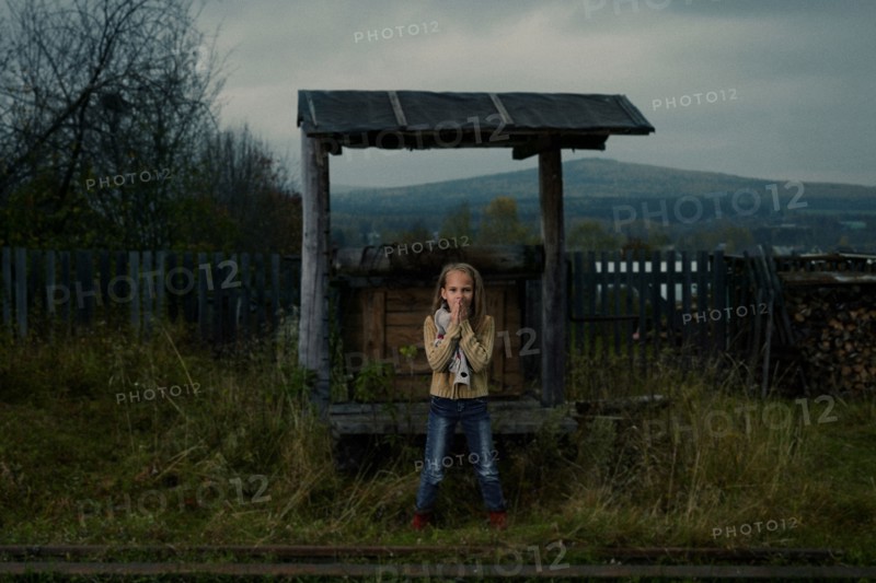 Caucasian girl waiting at rural train stop