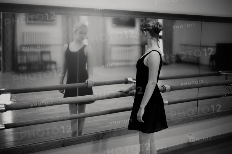 Caucasian ballerina standing at barre