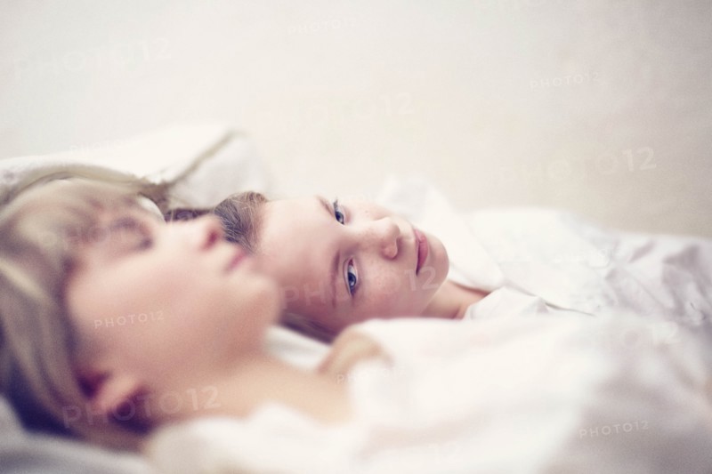 Caucasian girls laying on bed