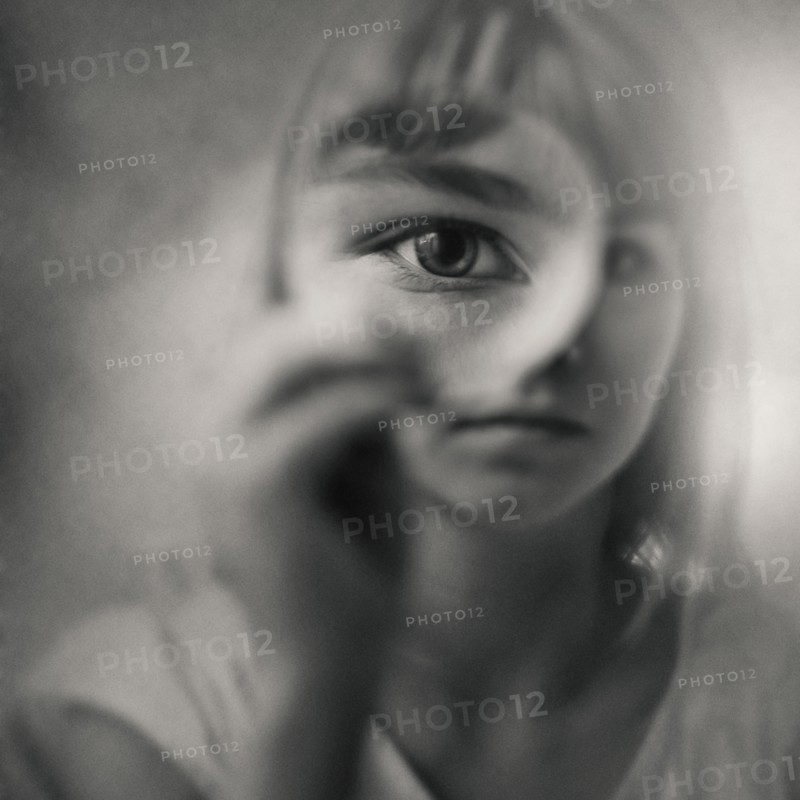 Caucasian girl looking through magnifying glass