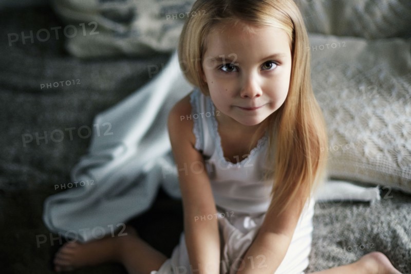 Caucasian girl smiling on bed