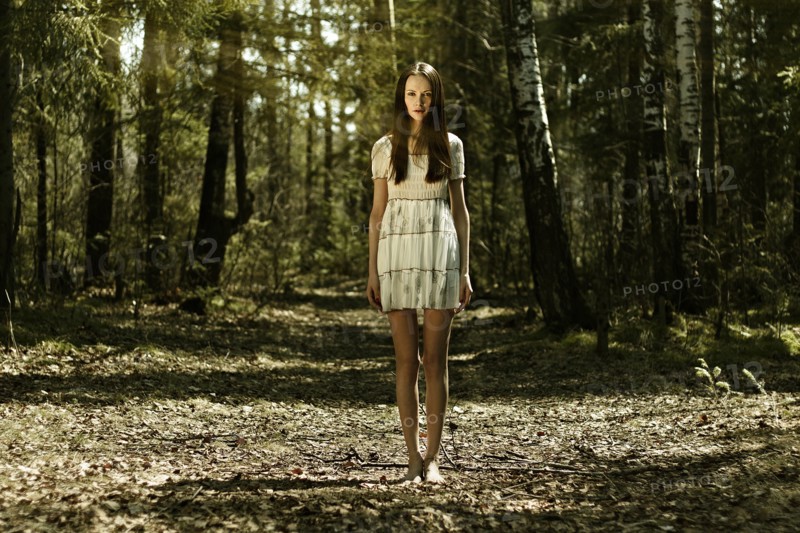 Barefoot Caucasian woman standing in forest
