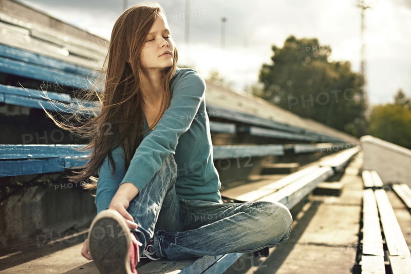 Caucasian woman sitting on bleachers