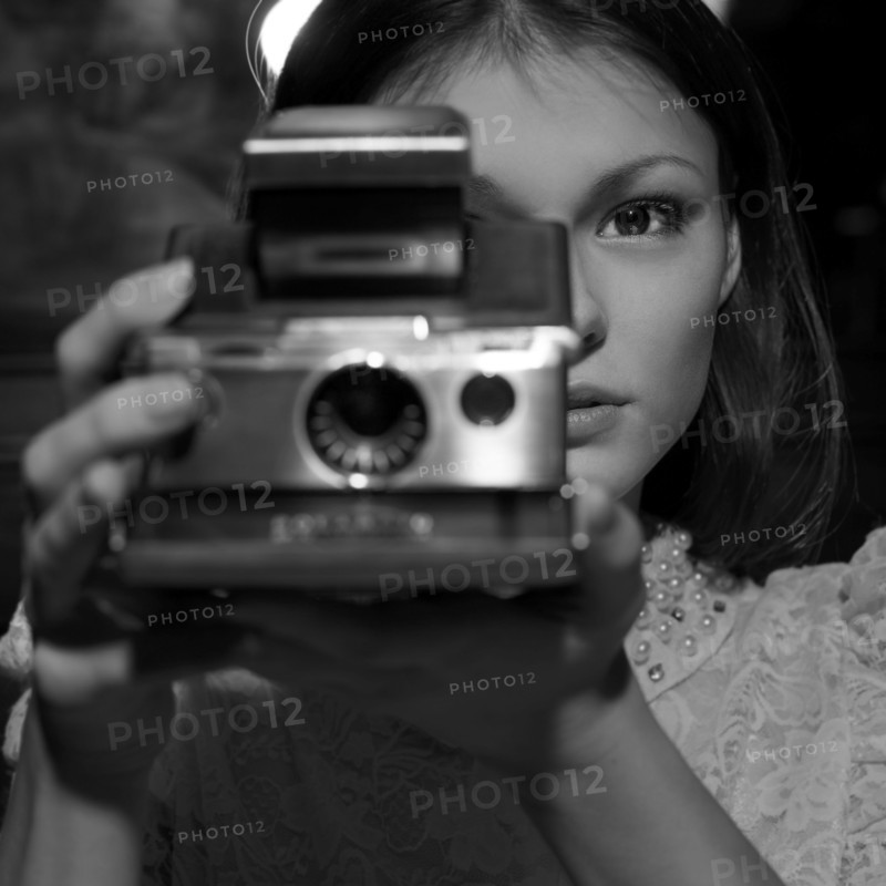 Caucasian teenage girl photographing with instant camera