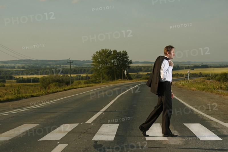 Caucasian businessman crossing rural street