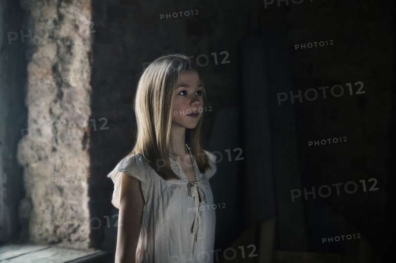 Caucasian girl standing at window