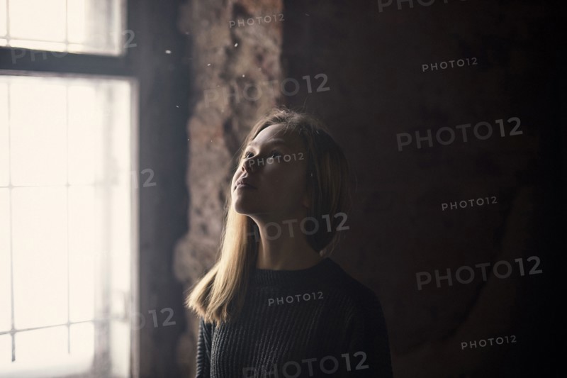 Caucasian girl standing at window