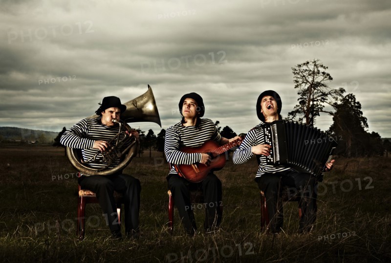 Caucasian band playing instruments in field