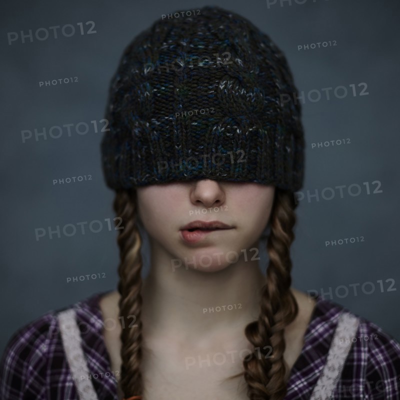 Caucasian girl wearing beanie hat over eyes