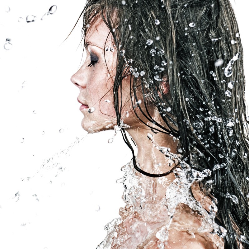 Face of Caucasian girl splashing in water