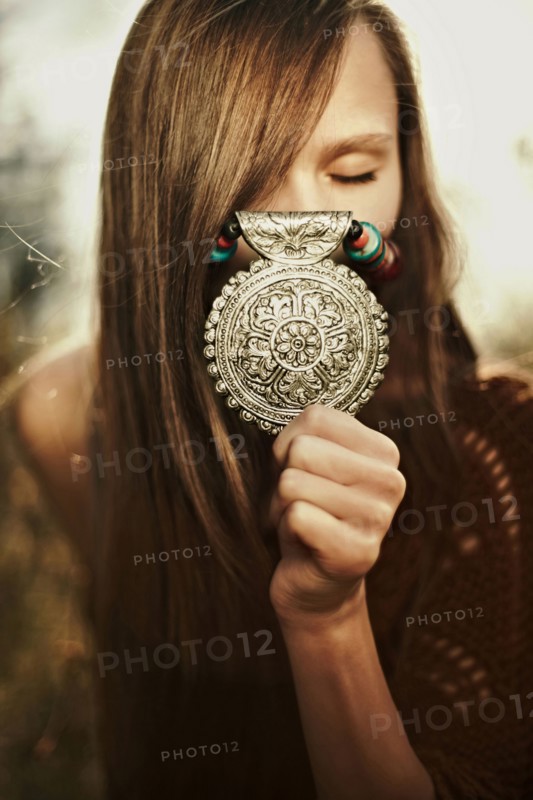 Close up of Caucasian woman showing medallion