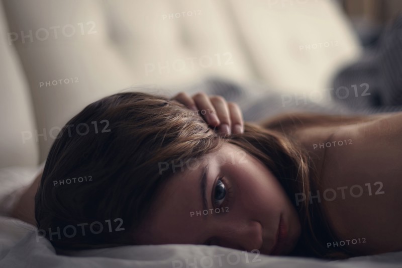 Caucasian teenage girl laying on bed
