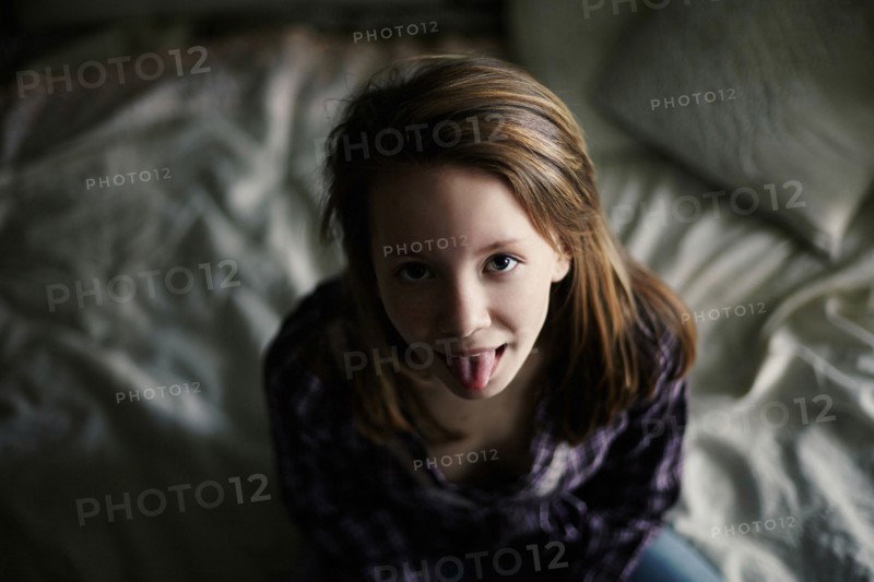 Caucasian teenage girl sticking out tongue