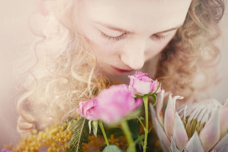 Caucasian teenage girl smelling bouquet of flowers