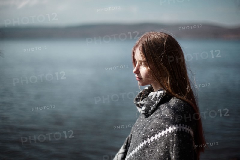 Pensive Caucasian girl at lake