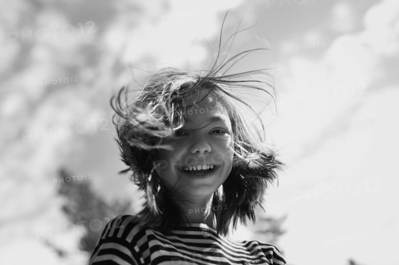 Smiling Caucasian girl with hair blowing in wind