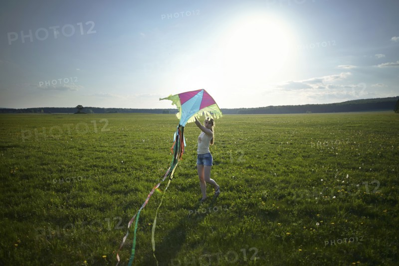 Caucasian girl standing in field holding kite