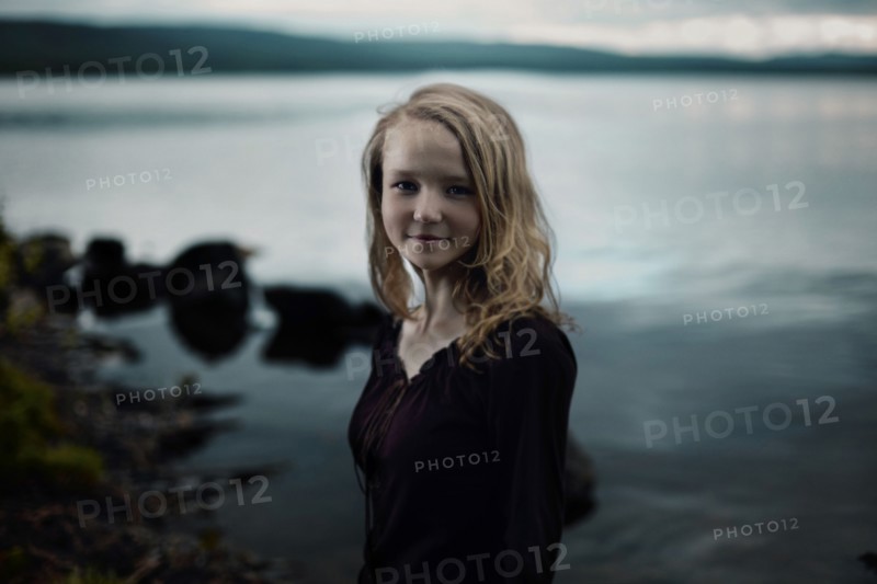 Smiling Caucasian girl standing at lake