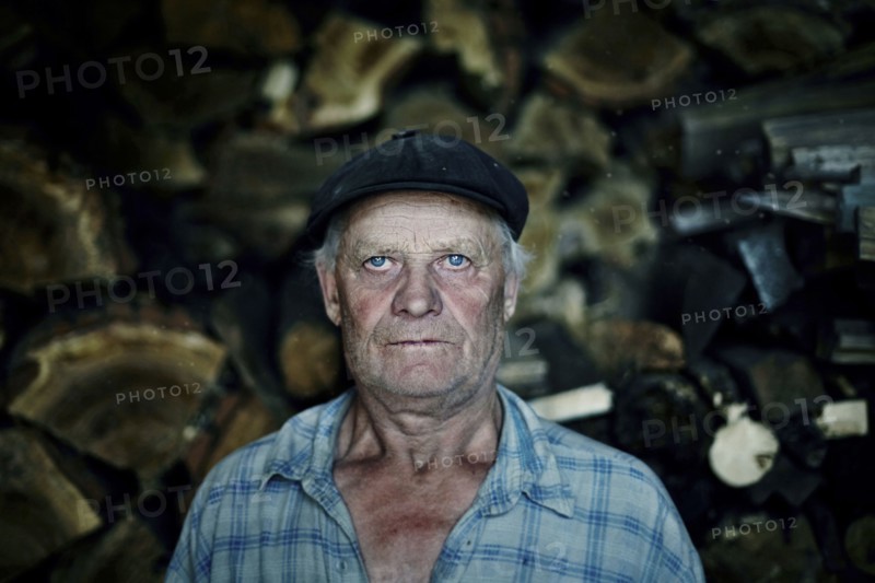 Serious Caucasian man near woodpile