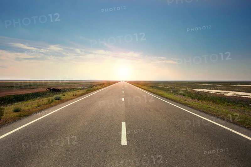Sunset over distant empty highway