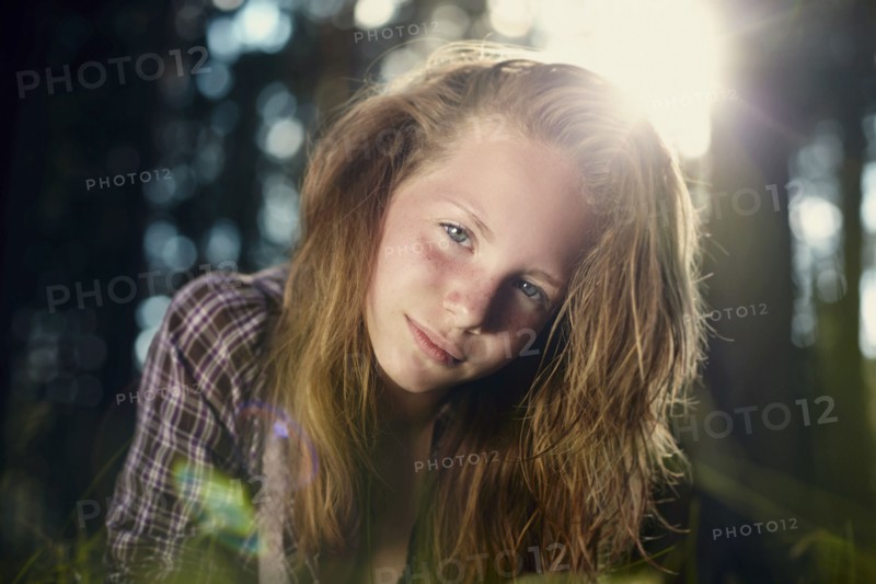 Serious Caucasian girl in sunny forest