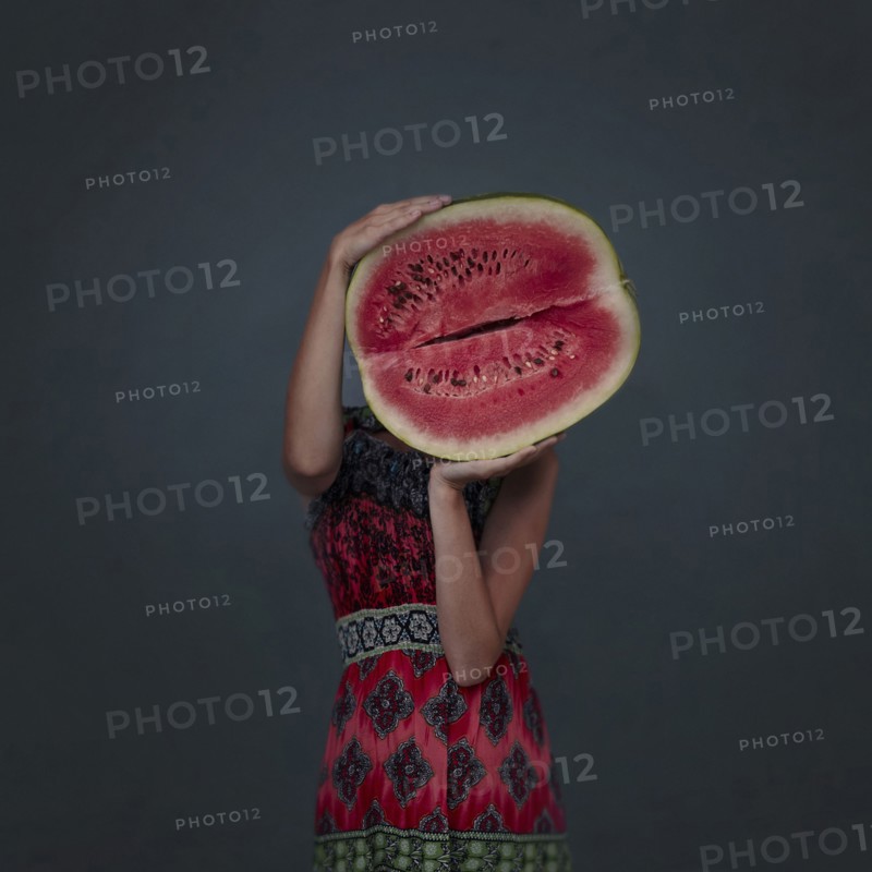 Caucasian girl holding enormous sliced watermelon
