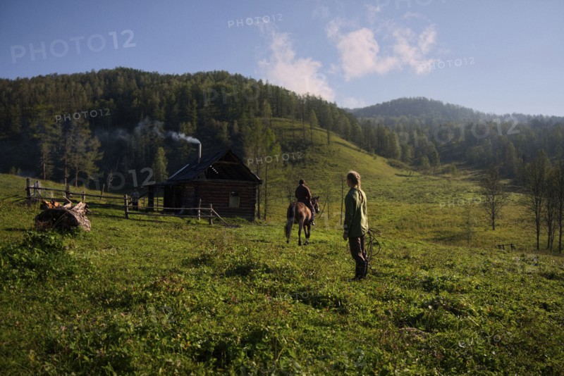 Caucasian girl watching girl riding horse