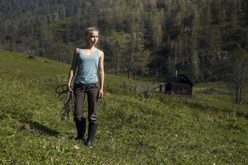 Caucasian girl holding rope on hill