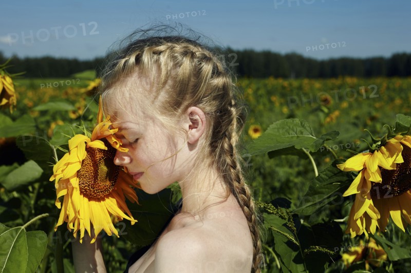 Caucasian girl smelling sunflower