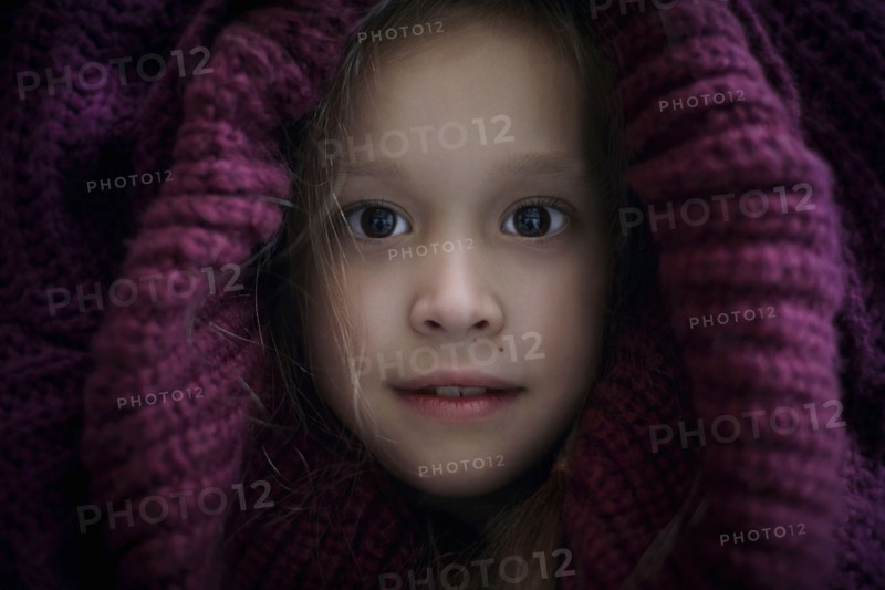 Portrait of Caucasian girl covering head with sweater