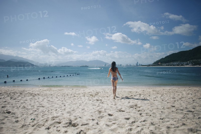 Caucasian woman wearing bikini running on beach