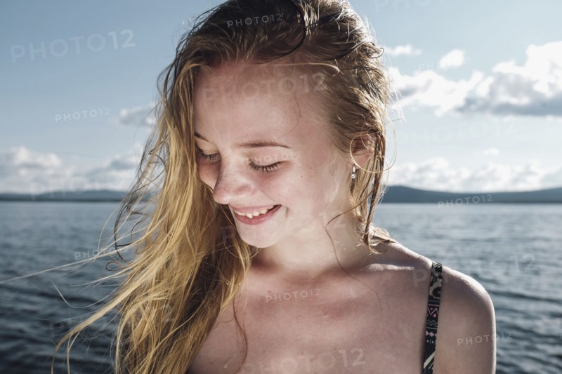 Wind blowing hair of Caucasian teenage girl in ocean