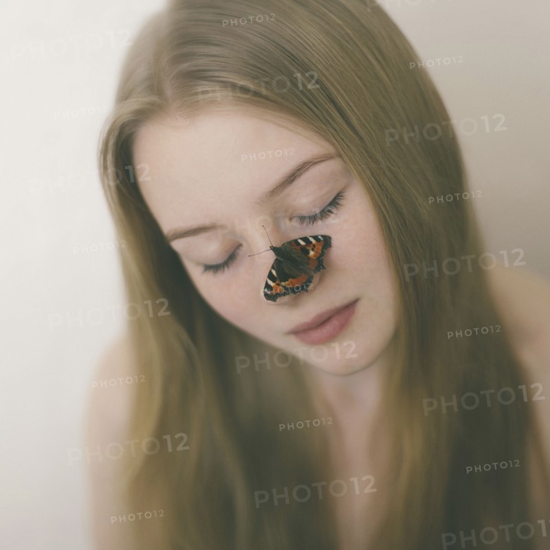 Butterfly on nose of Caucasian teenage girl