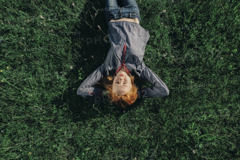 Caucasian teenage girl laying in grass
