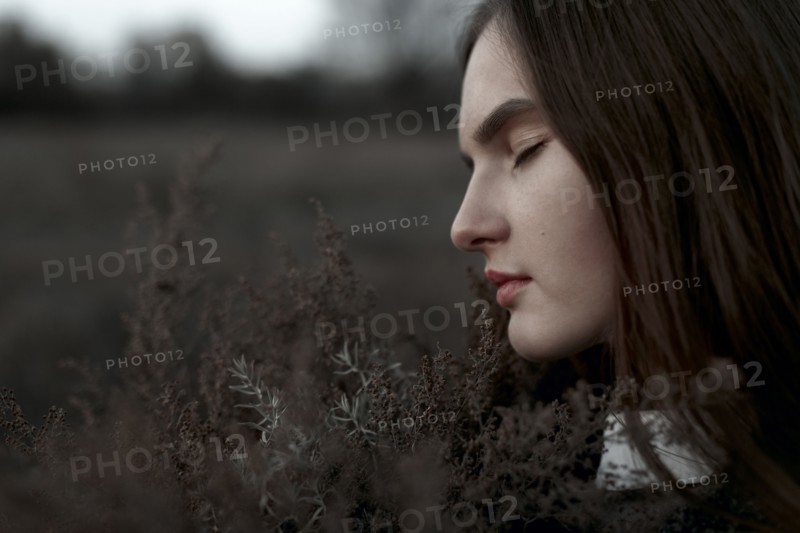 Caucasian woman smelling foliage