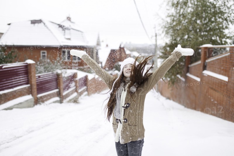 Caucasian girl throwing snow outdoors