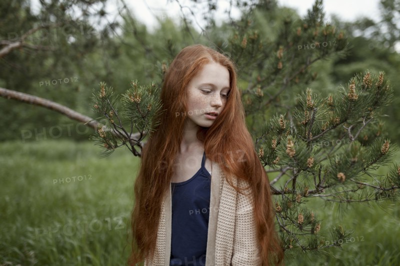Caucasian girl standing near tree branch