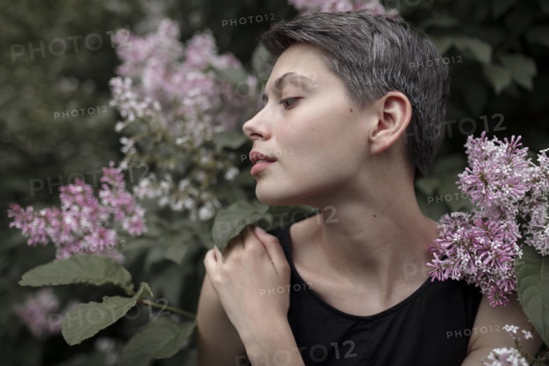 Profile of Caucasian woman standing in flowers