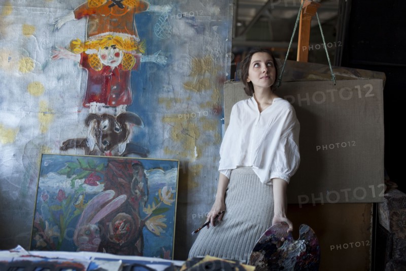 Caucasian artist holding paintbrush and palette