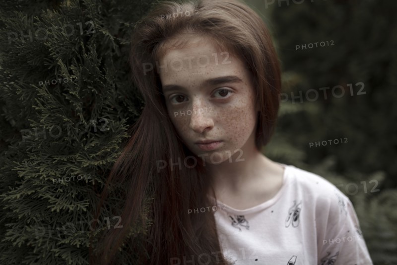 Portrait of serious Caucasian girl with freckles