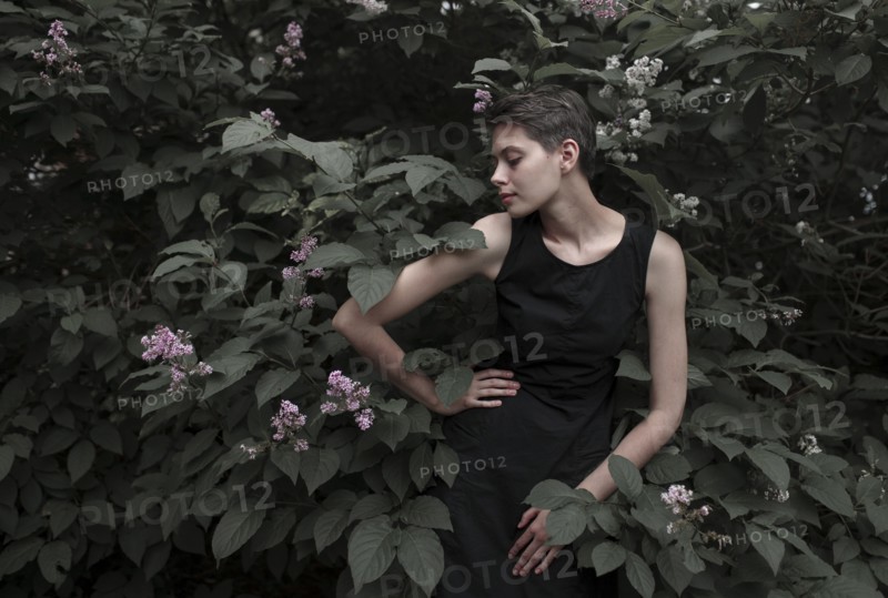 Caucasian woman near flowering tree with hand on hip