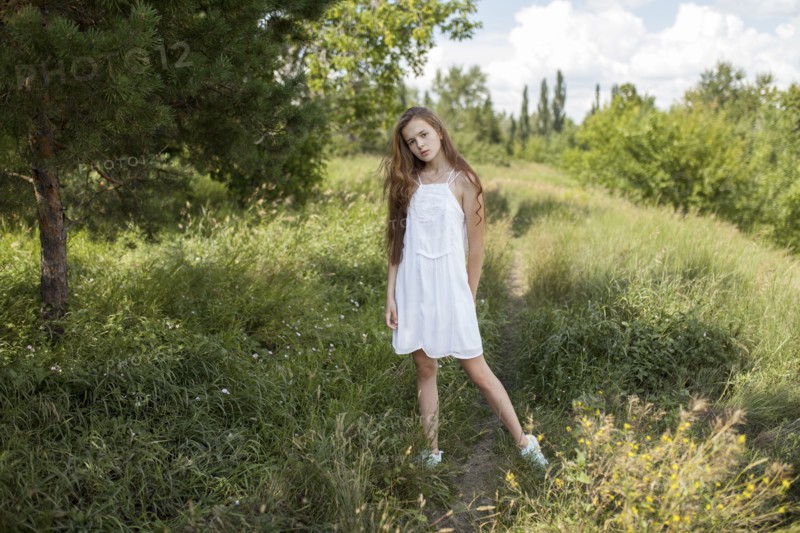 Caucasian girl standing in field of grass